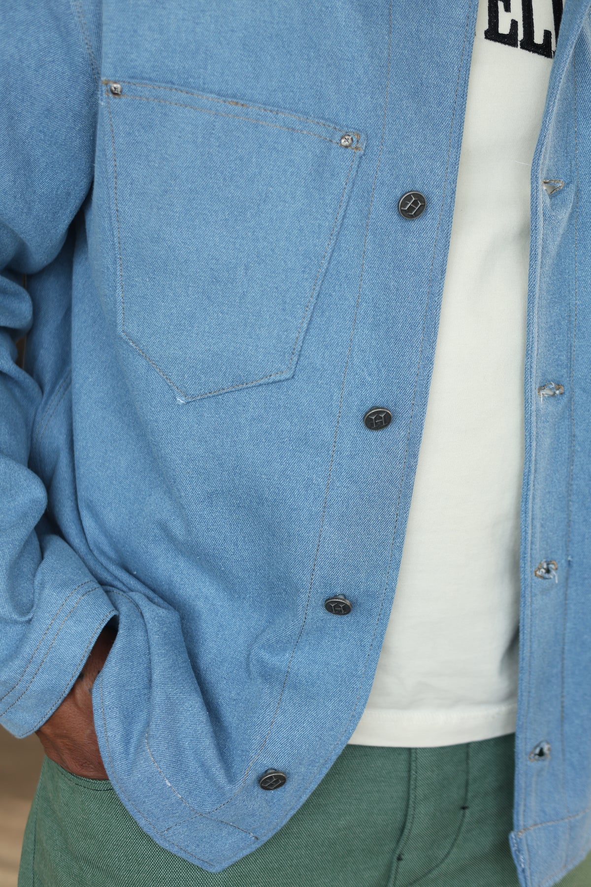 Close-up of Hues Atelier light-wash denim Work Jacket with button-front detailing