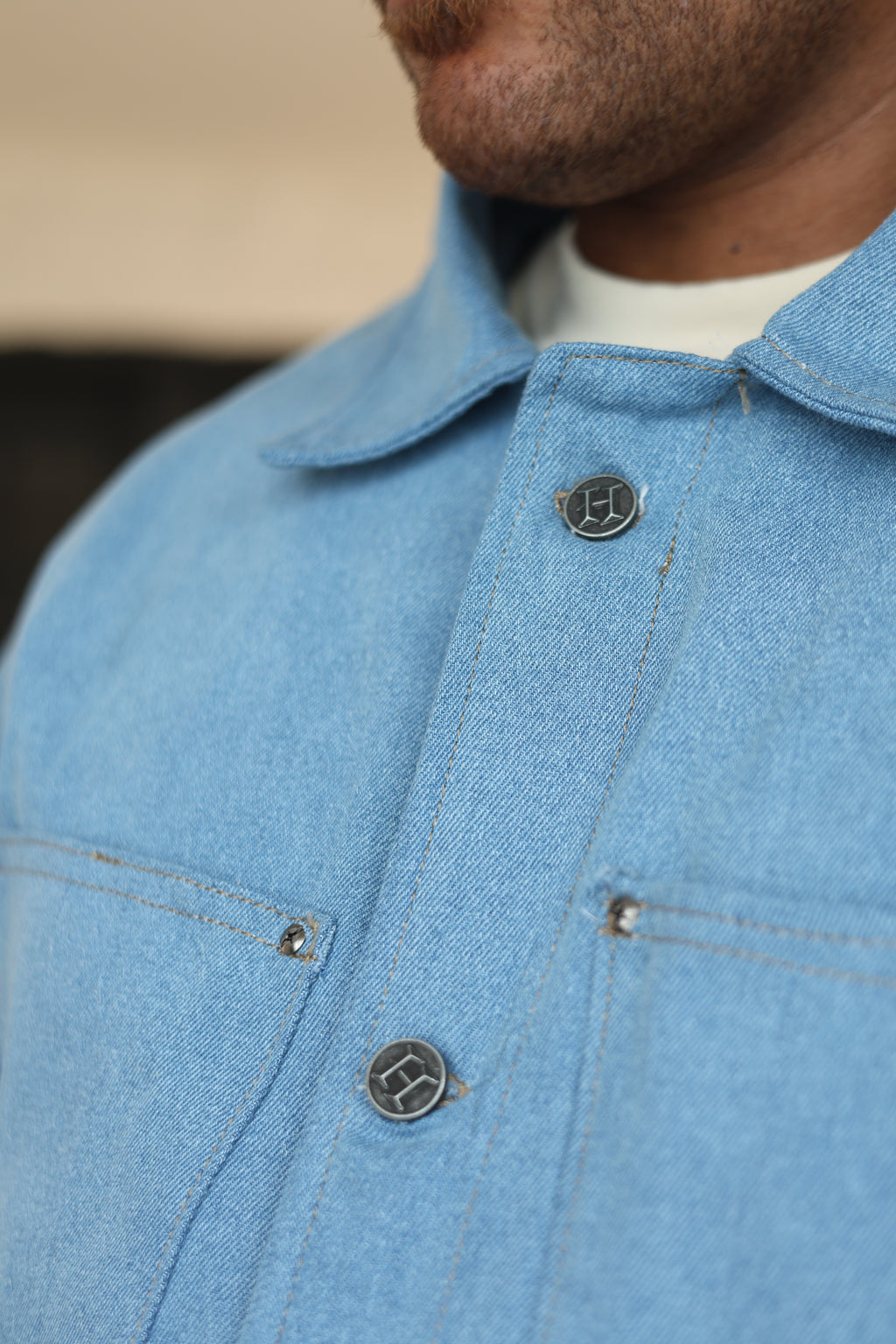 Close-up of model wearing light-wash Hues Atelier denim Work Jacket