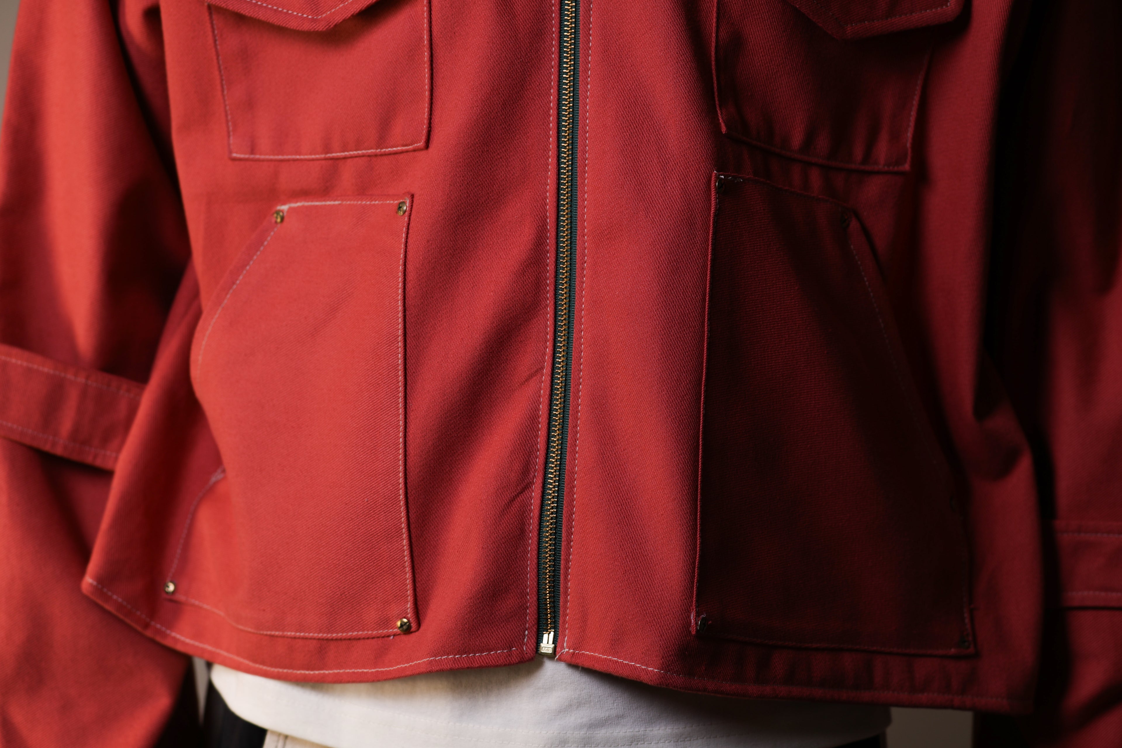 Close-up of a red jacket with a zipper and pockets.
