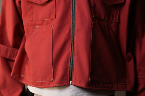 Close-up of a red jacket with a zipper and pockets.