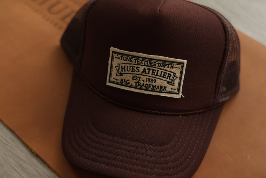 Mocha Hues Atelier Trucker Hat with embroidered front patch and mesh panels