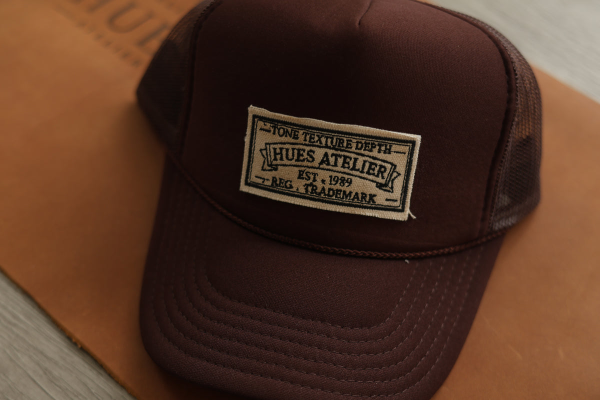 Mocha Hues Atelier Trucker Hat with embroidered front patch and mesh panels