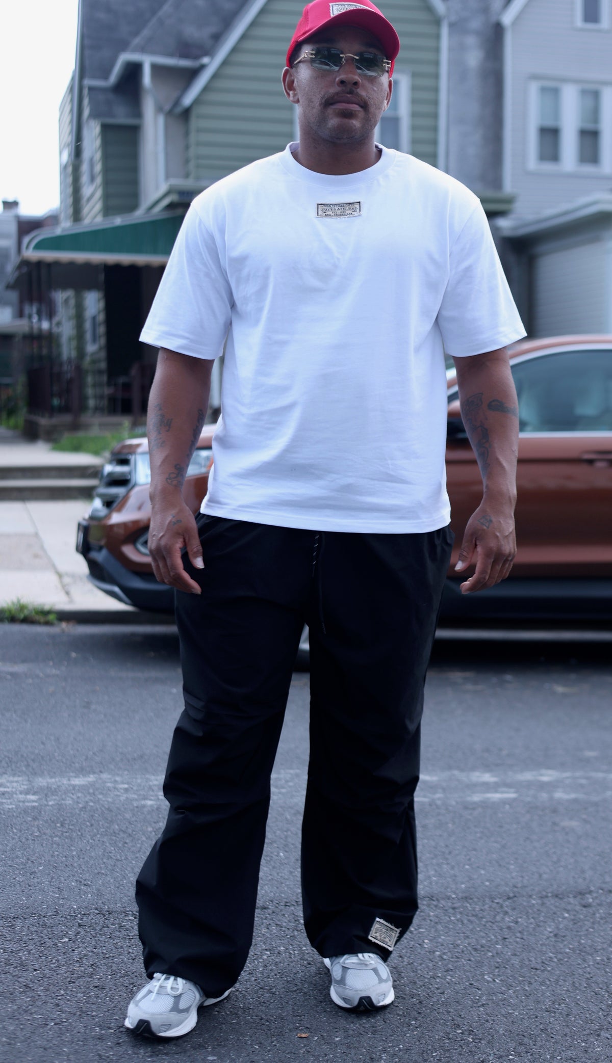 Model wearing black Hues Atelier Track Pants and white T-shirt outdoors